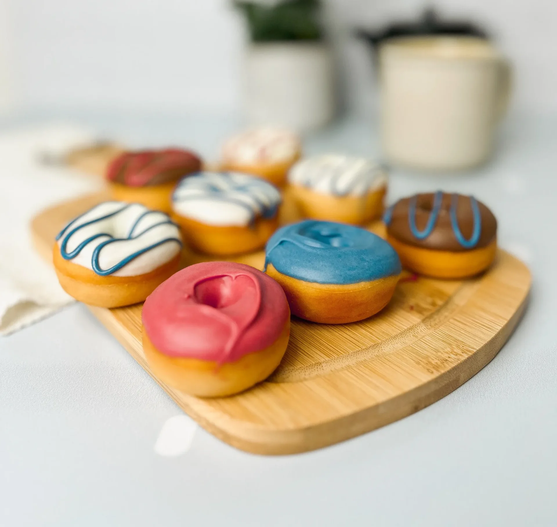 Mini donuts congelados: alternativa perfeita para quiosques e parques 1 Mini donuts em uma tábua marrom, com frosting.