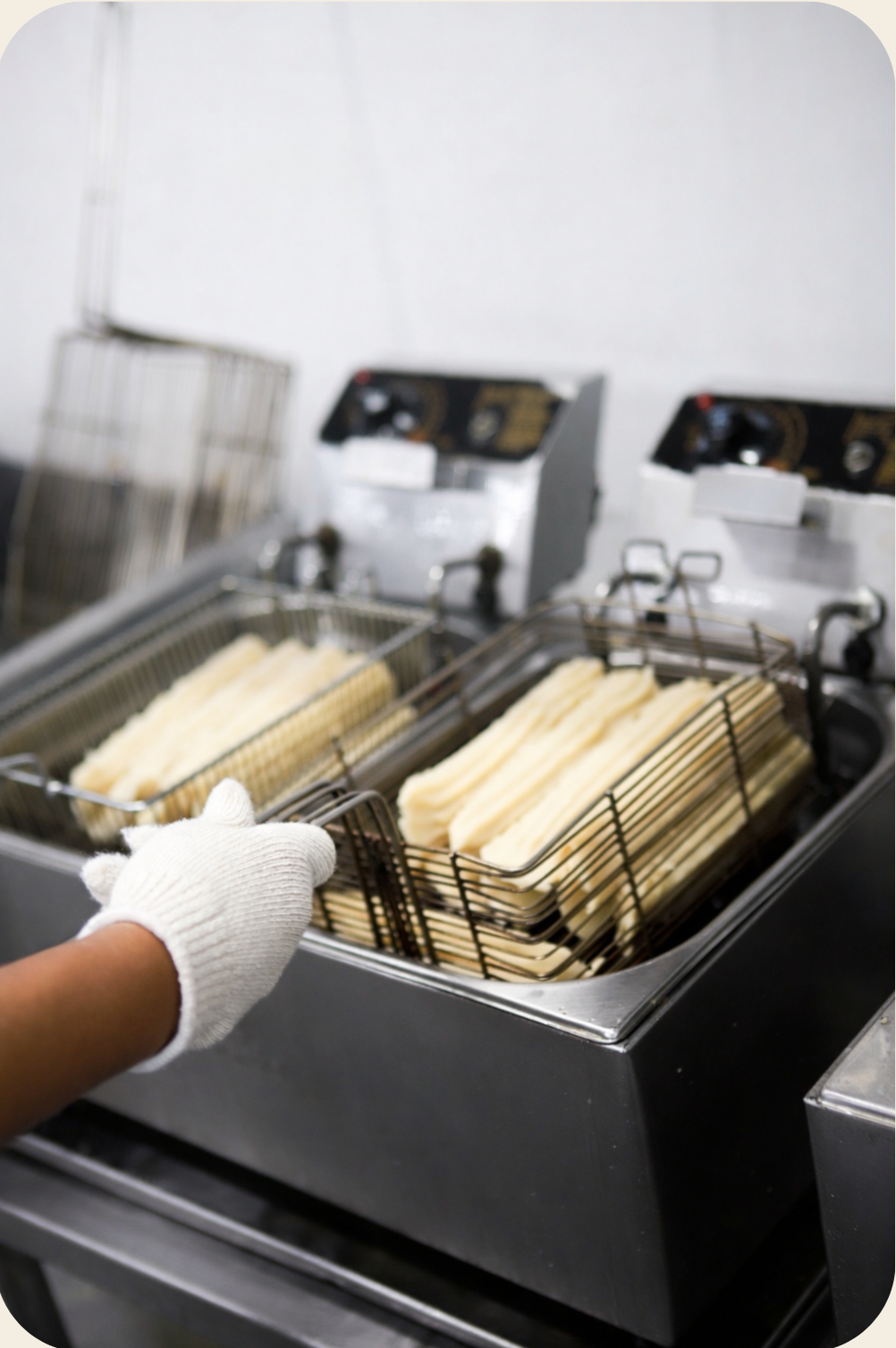 Fritadeira com oleo quente fritando churros congelados.
